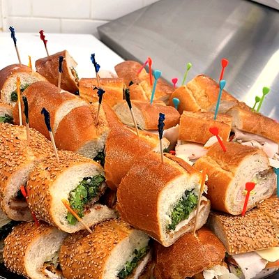 A party tray of hoagies cut into pieces and held with picks